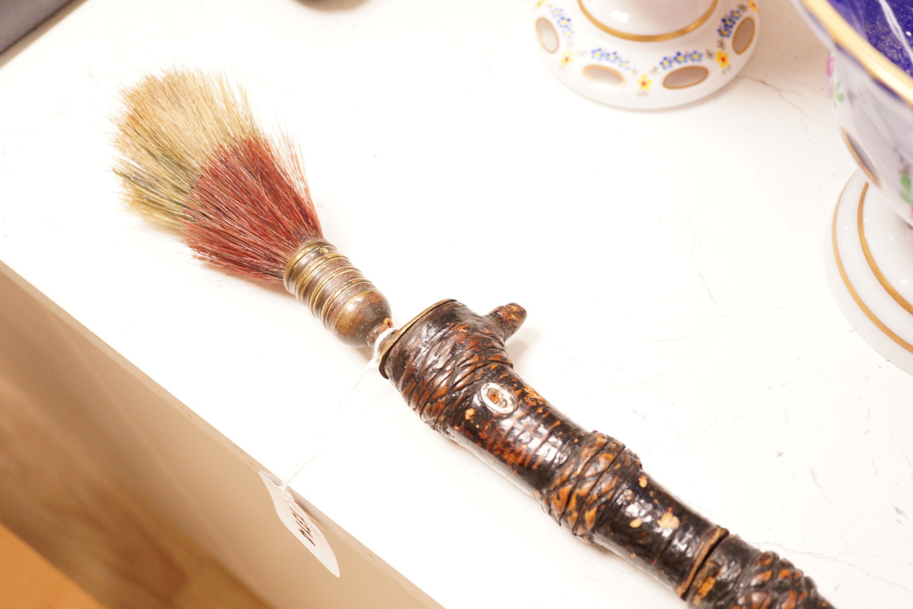 A ceremonial sword stick with removable brush end